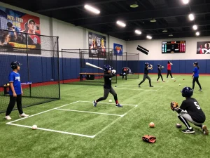 Young athletes at hitclub practicing baseball in vibrant gym.